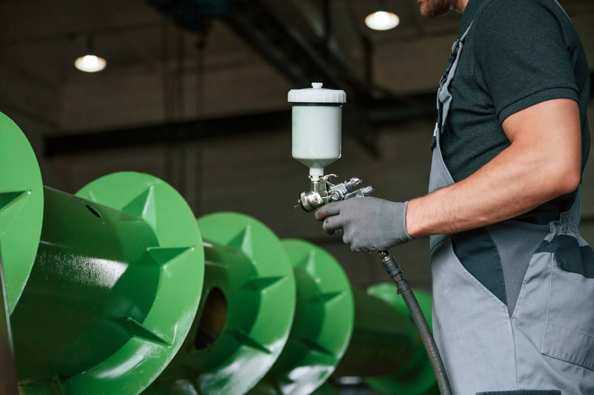 Painting details. Man in uniform is in workstation developing details of agriculture technique.
