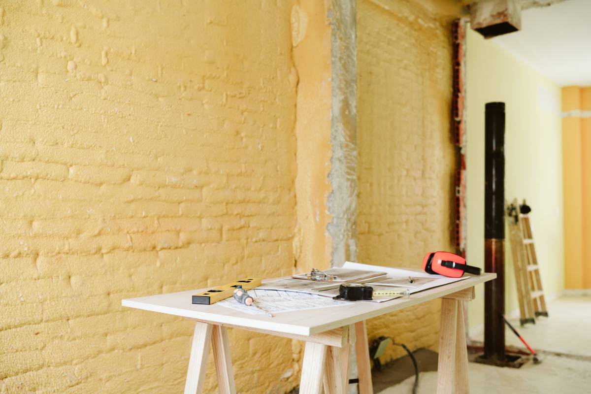 blueprints, ear defenders, protection glasses and tools on architect workspace at construction site